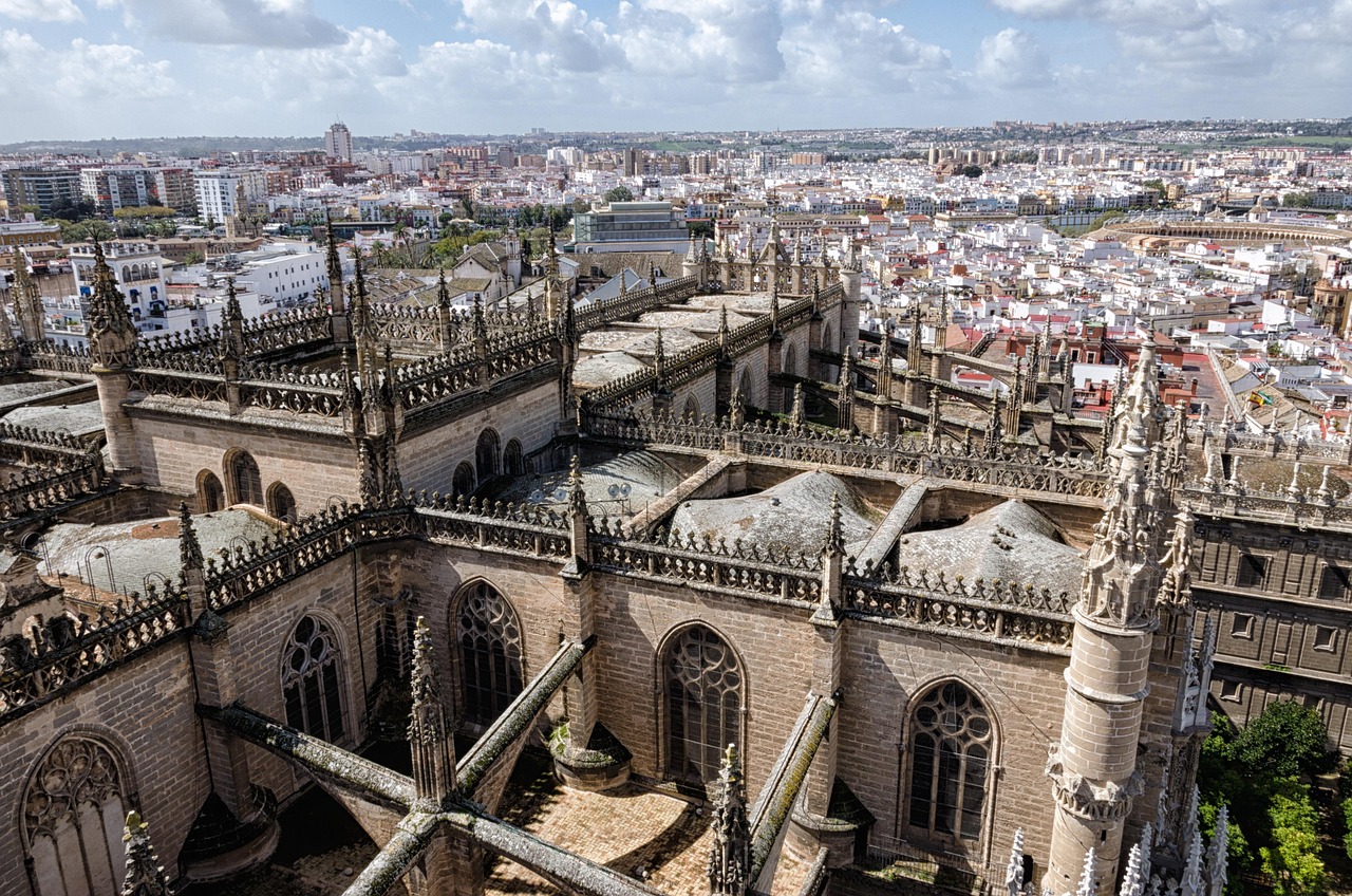 Coberturas, pináculos e arcobotantes da Catedral de Sevilha, com a cidade ao fundo