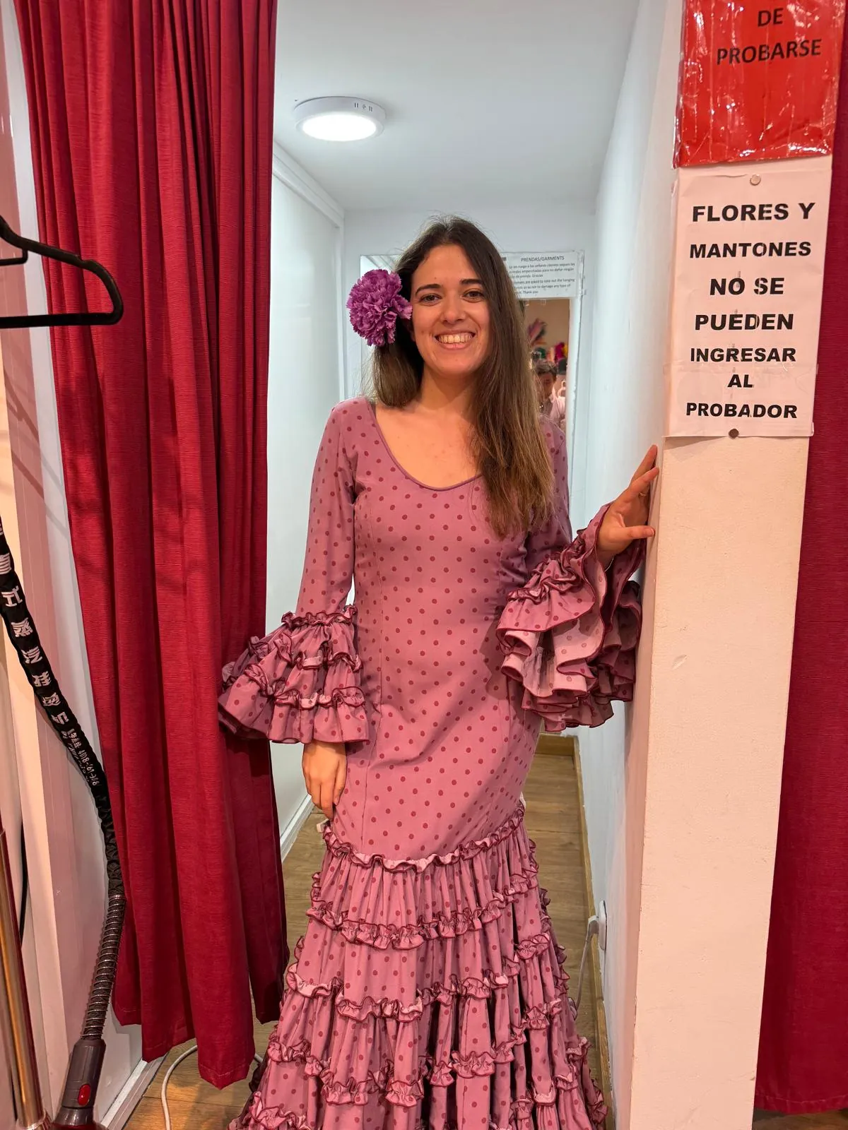 Alexandra a experimentar um vestido de flamenca rosa com folhos, num provador