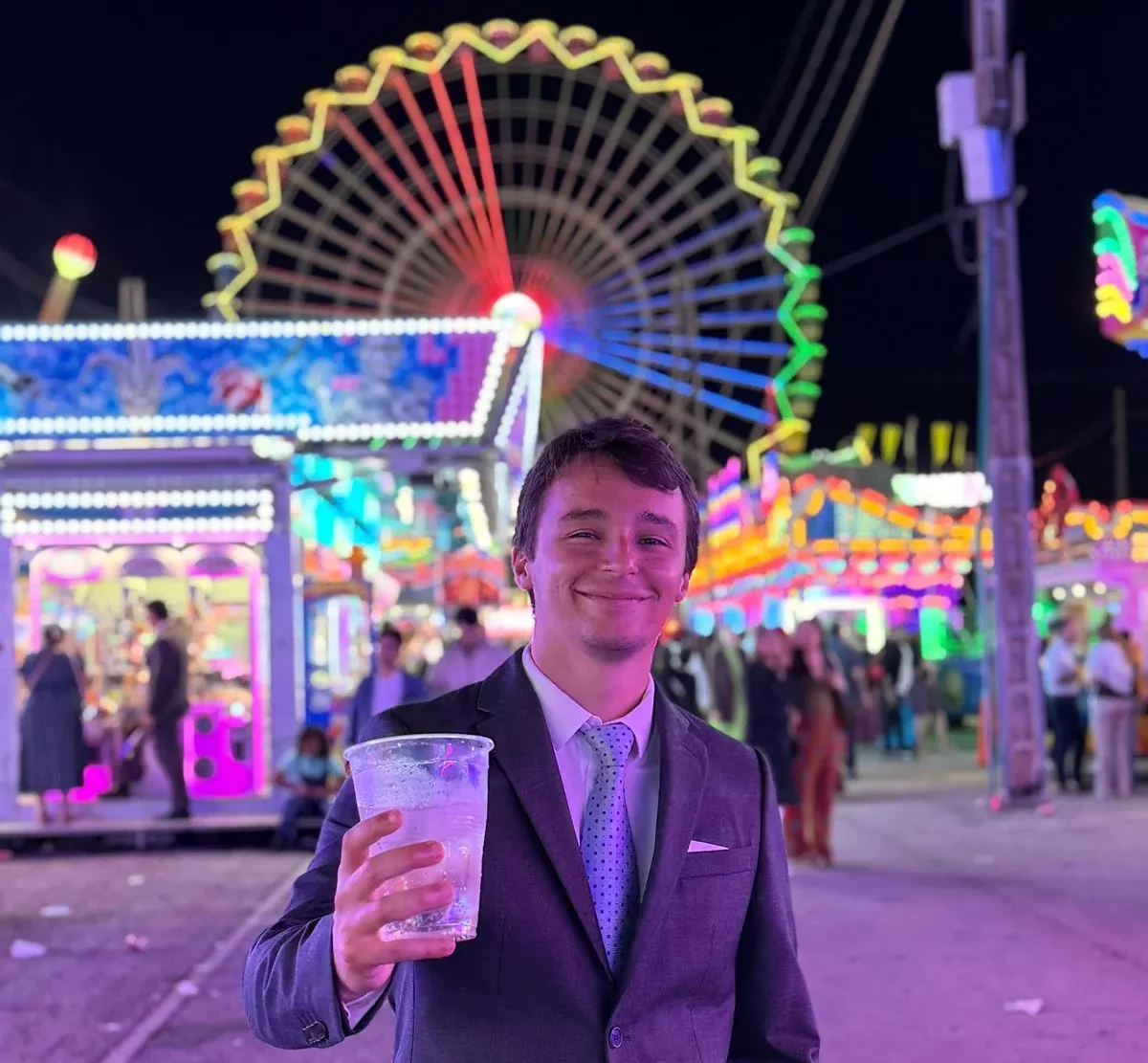 Vítor com um copo de rebujito na zona de diversões da Feria de Abril, à noite
