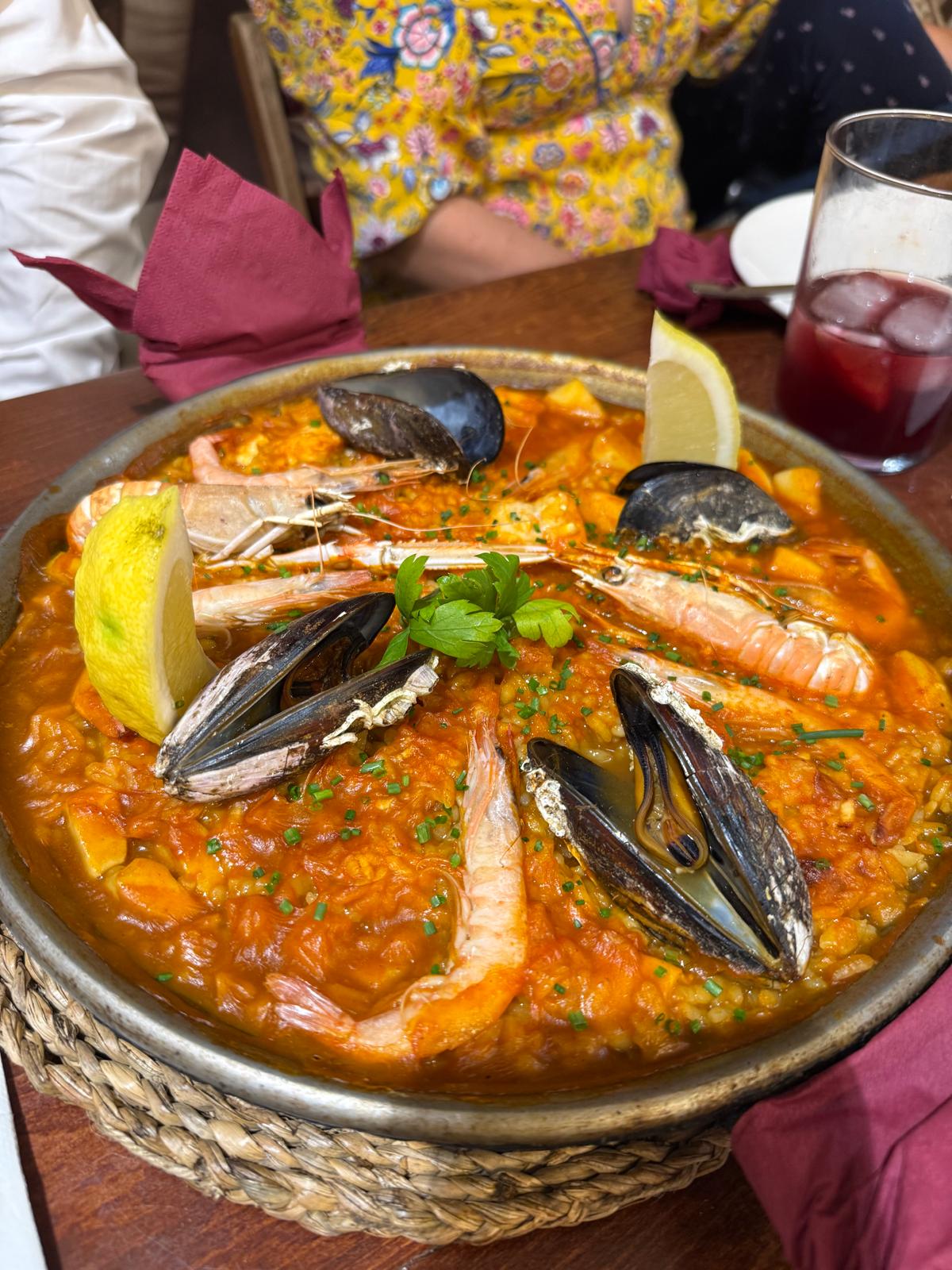 Arroz com camarões e mexilhões numa frigideira, servido à mesa em Sevilha